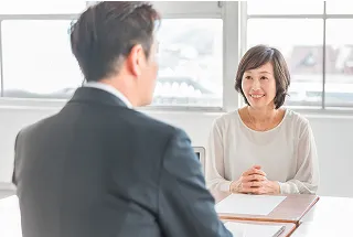向かい合って椅子に座って懇談する様子